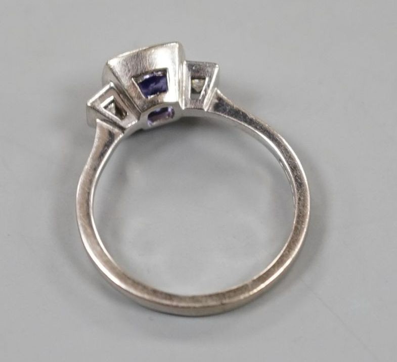 A modern 18ct white gold, single stone tanzanite and two stone diamond set ring, size R, gross weight 5 grams.